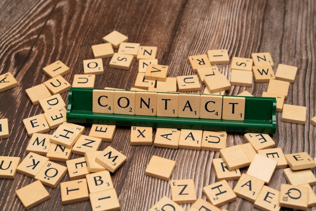 The word contact is spelled out with wooden letters